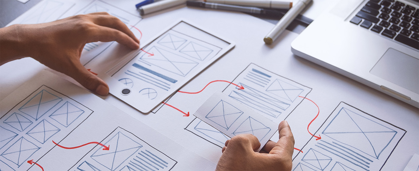 designer using paper to layout potential responsive design options